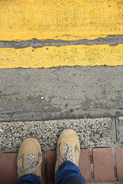 istock people legs waiting the traffic light on zebra crossing road 577974862