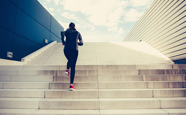 Climbing Up The Stairs Woman exercising on a staircase outside in the  city. climbing staircase stock pictures, royalty-free photos & images