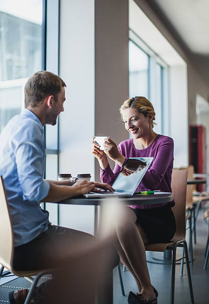 istock Business Couple Sitting at the Table and Using Portable Devices 577980376