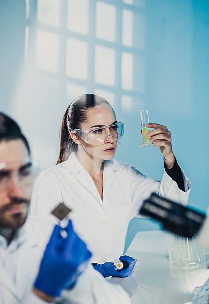 istock Scientists Looking at the Measuring Cylinder 578075252