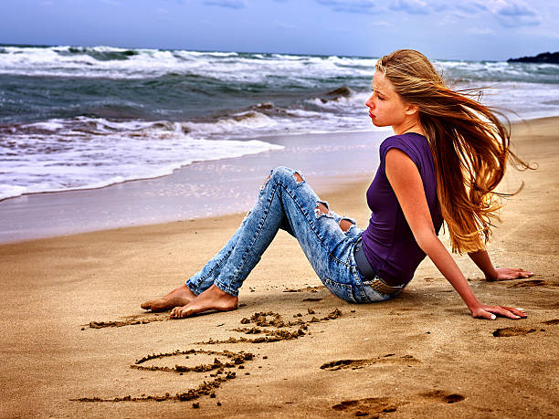 Summer girl sea. Teenager writting love on sand. Summer dreams of girl on sea beach.