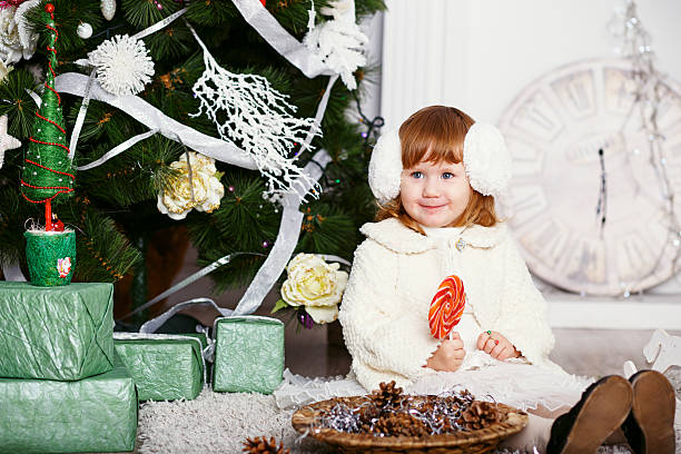 menina comendo um pirulito - clock baby christmas small - fotografias e filmes do acervo