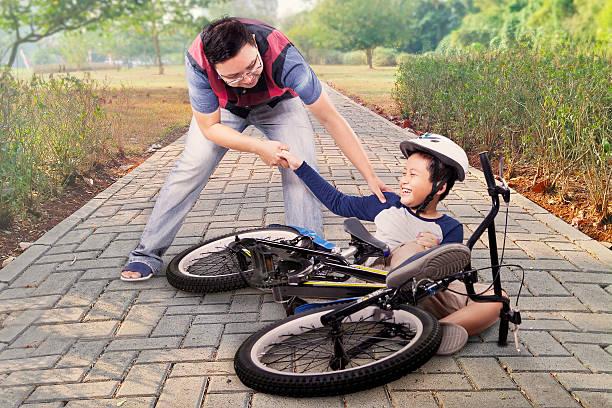 istock Child gets crash and helped by dad 578081254