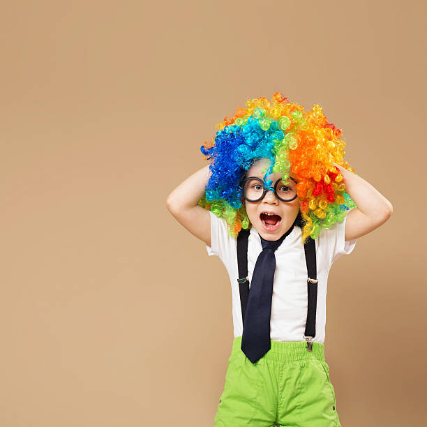 大きなカラフルなかつらと幸せなピエロの少年。 - entertainment clown child circus ストックフォトと画像
