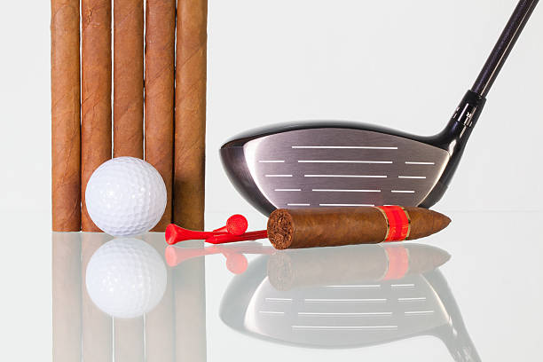 istock Golf driver and different cigars on a glass desk 578083012