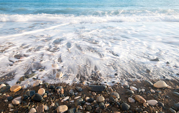 istock Pebbles  in the beach with soft milky sea water 578083472