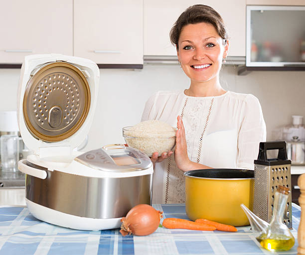 istock Woman cooking with multicooker at home 578083484