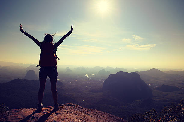 istock cheering woman hiker at sunrise mountain peak 578084194