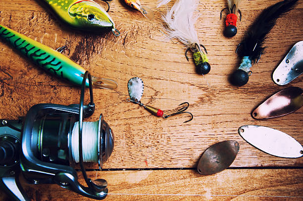istock Fishing baits and rod isolated on wooden background 578084282