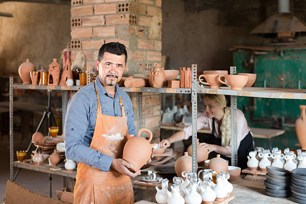 istock man potter holding ceramic vessels in atelier 578087382