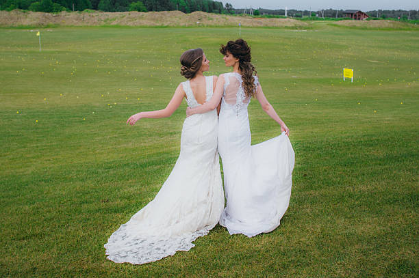 istock Two beautiful brides embracing on the green field 578087752
