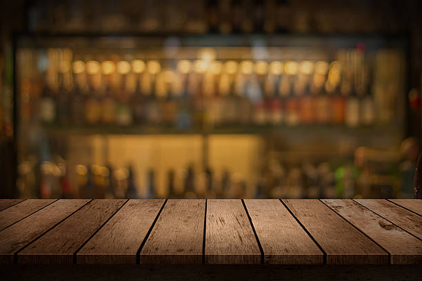 tableau en bois avec une vue sur fond flou boissons de bar - beer bar counter bar drink photos et images de collection