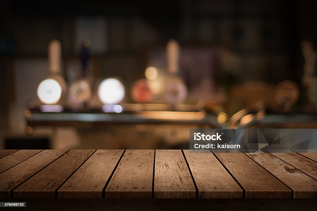 wooden table with a view of blurred beverages bar backdrop Table Stock Photo