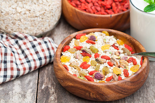 fresh  breakfast of granola yogurt nuts goji berries and raisins