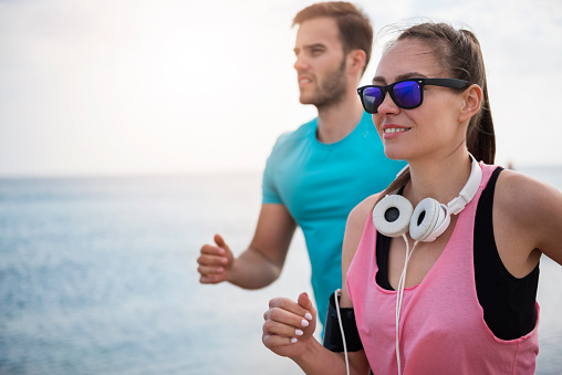 Man and woman jogging together on sunny day