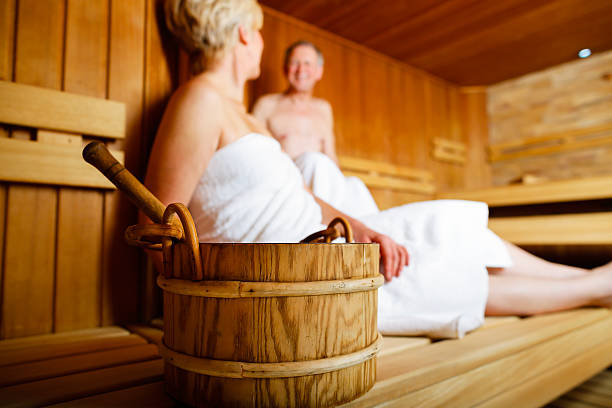 пожилые люди в сауне потливость и расслабляющий - sauna health spa healthy lifestyle wellbeing стоковые фото и изображения