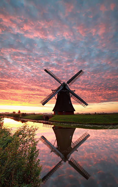 istock Dutch windmill and dramatic red sunrise by river 578099824