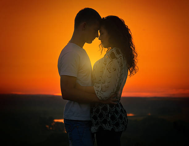 istock young couple at sunset on sky background, love concept 578100698