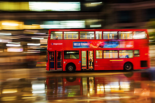 London, UK - June 19, 2016: red double decker bus in motion blur in London night traffic. The famous red buses are one of the main iconic symbols of London.