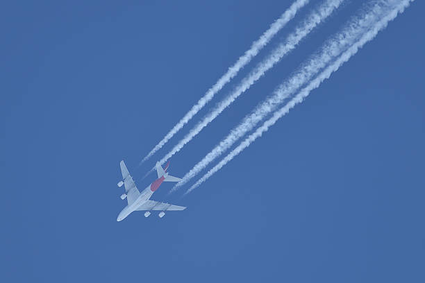 istock Flying airplane on the blue sky leaving white lines behind 578102204