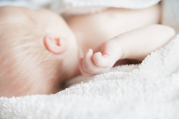 istock Sleeping newborn baby covered with white blanket. 578103266