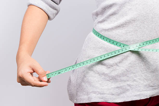 istock Woman measuring her waist 578104286