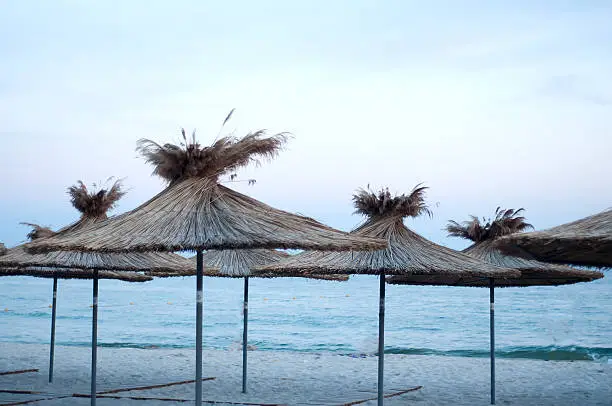 Photo of many sun umbrellas in the warm sandy beach