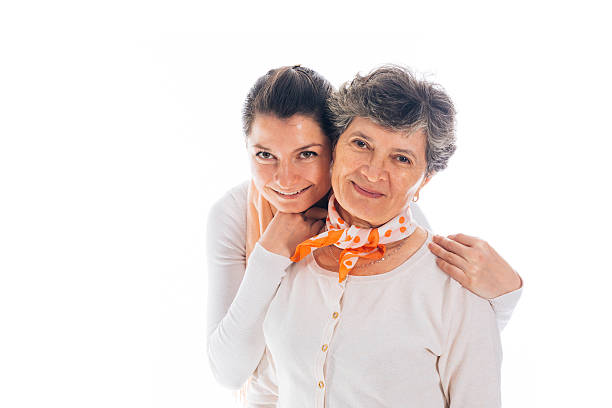Photo of young caregiver holding elderly woman hands