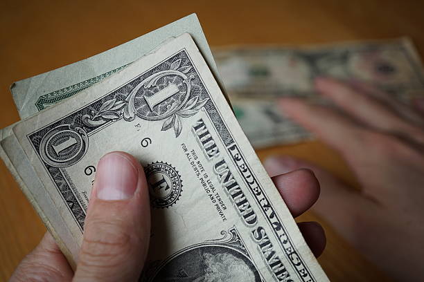 istock Two male hands holding set of paper banknotes (USD) 578105420
