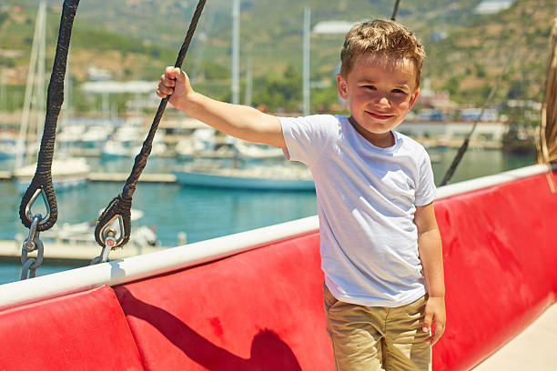 istock Funny little boy posing on excursion boat near beautiful mountines 578105660