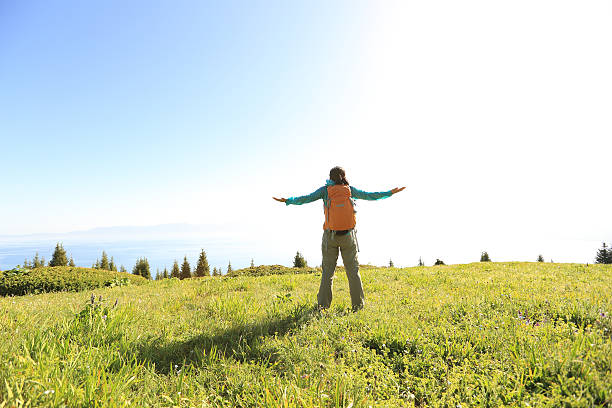 istock cheering young woman backpacker open arms at mountain peak 578106284