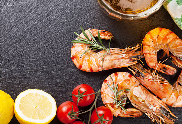istock Beer mug and grilled shrimps on stone plate 578106396