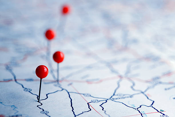 Push Pins On A Road Map A row of four push pins on a road map.  The road map is very generic with no town names or landmarks legible.  The image is photographed using a very shallow depth of field. navigational equipment photos stock pictures, royalty-free photos & images