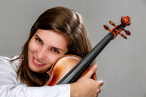 istock Young woman posing and embracing violin 578109108