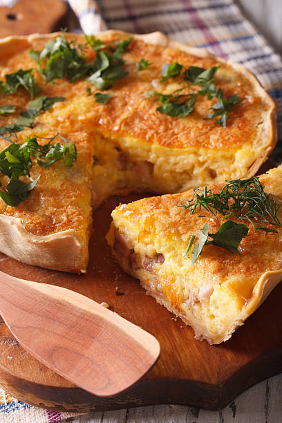 istock Sliced quiche with cheese, eggs and bacon close-up on board 578110026