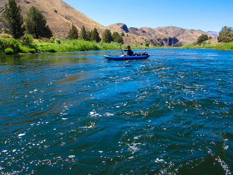 Kayaker on the John Day River in central Oregon. Pacific Northwest.