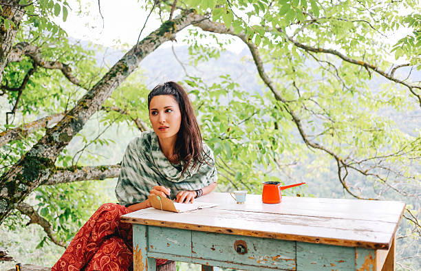 istock Young woman writing in the beautiful nature 578111724