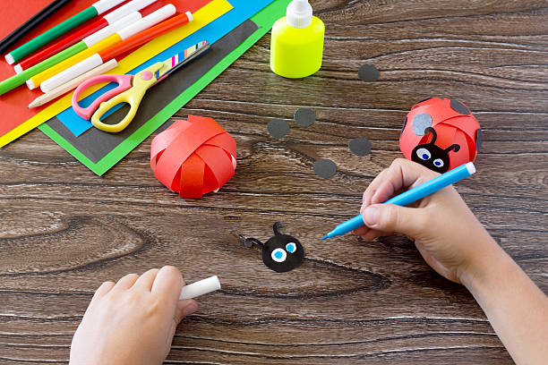 istock The child makes crafts out of paper ladybug. 578113320
