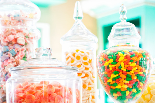 Close up of various ornate jars full of candy.