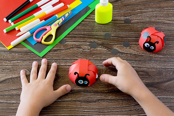istock The child makes crafts out of paper ladybug. 578113668