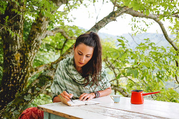 istock Young woman writing in the beautiful nature 578114436