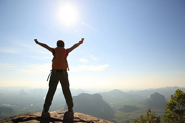 istock cheering woman hiker at sunrise mountain peak 578119778