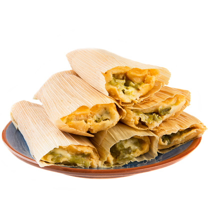 Cheese and chili tamales on plate and isolated on white background, viewed from eye level.