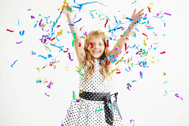 Image of little dancing girl wears beautiful dress on isolated pink background. Cheerful child is in happy mood.