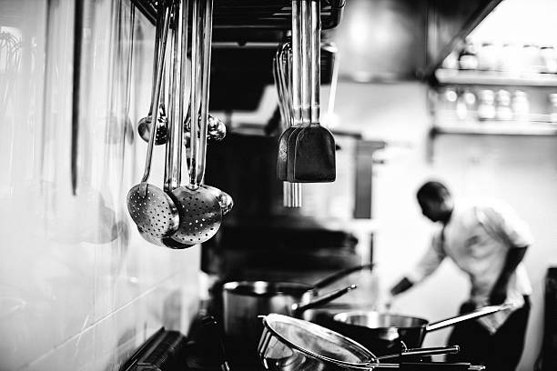 Chef working in a kitchen Chef working in a kitchen - Black and white image cooking pan photos stock pictures, royalty-free photos & images