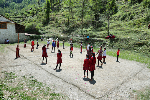 Tolka, Nepal - April 19, 2016: nepalese young kids playing volleyball with school uniform in the playground of a nepalese school in Tolka village, Nepal.