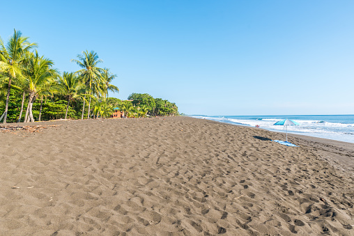 Sombrilla de playa y toalla en playa hermosa en Costa Rica photo