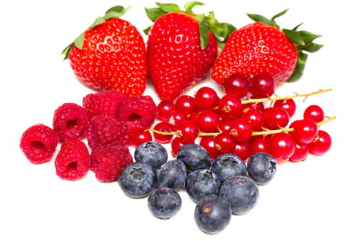 currants, raspberries and blueberries on white background 