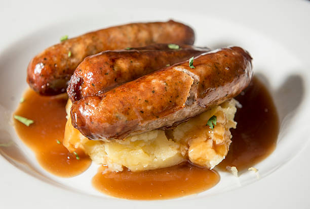 Traditional pub lunch - bangers with mash Bangers with mash - sausages with gravy and mashed potatoes mashed stock pictures, royalty-free photos & images