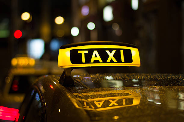taxischild bei nacht, taxi autos - taxi stock-fotos und bilder